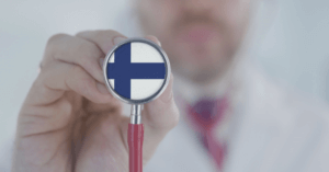Doctor holds stethoscope bell with the Finnish flag. Healthcare in Finland