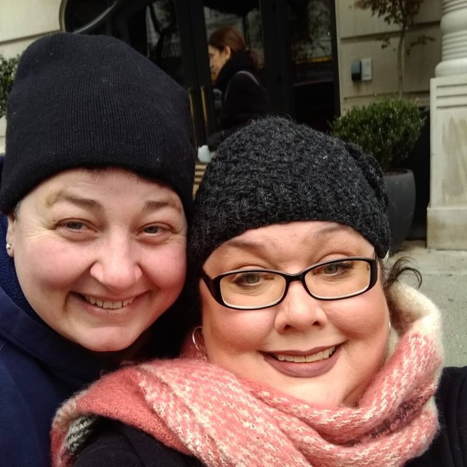 Two people smiling in winter hats.