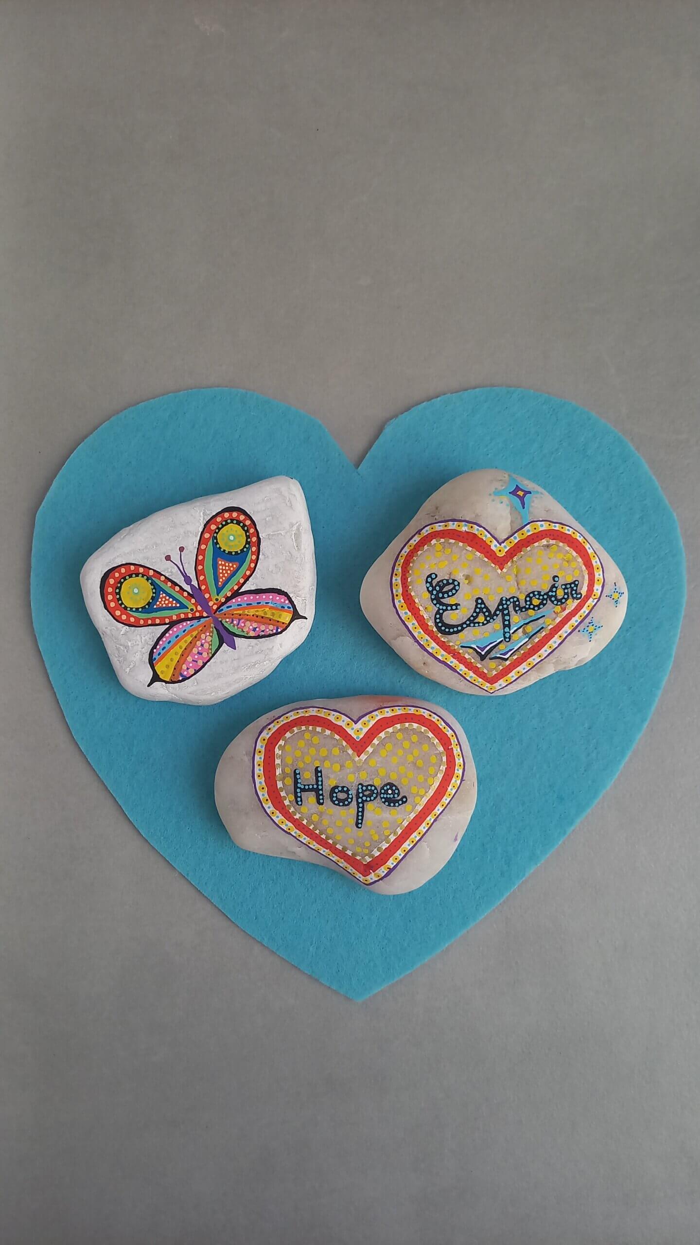 Rocks with a drawing of a butterfly, and hearts on them