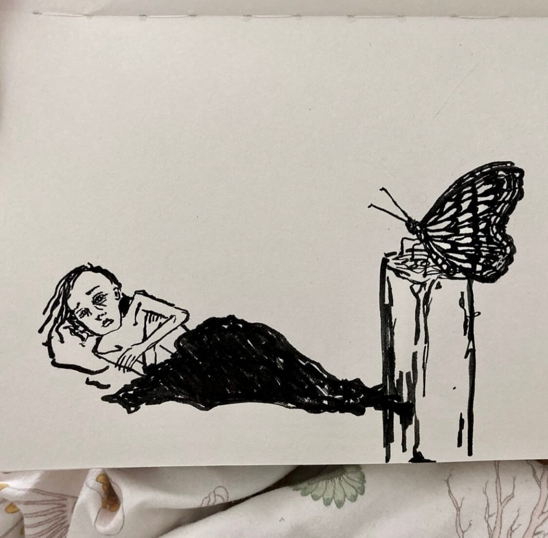 A person in bed with a black butterfly flying over them