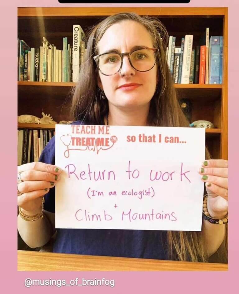 woman with long brown hair and wearing glasses in front of a book shelf is holding a sign that says teach me treat me so that i can return to work (im a ecologist) + climb mountains.