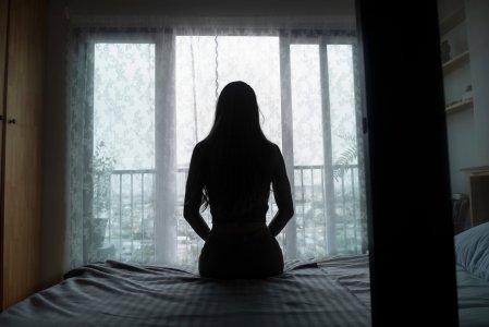 Silhouette,Of,A,Young,Woman,Sitting,On,A,Bed,Spending